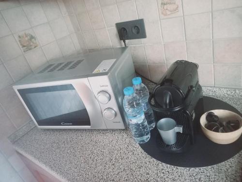 a microwave sitting on a counter with bottles of water at Charming Oasis in Marrakesh in Marrakech