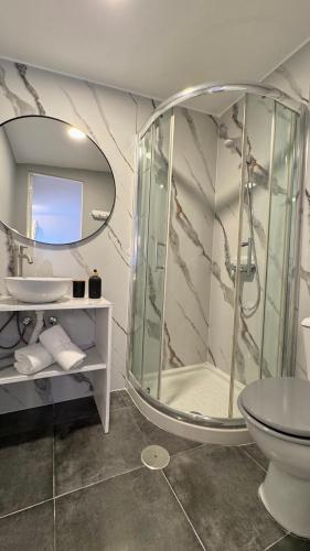 a bathroom with a shower and a toilet and a mirror at Concept Rooms in Costa de Adeje