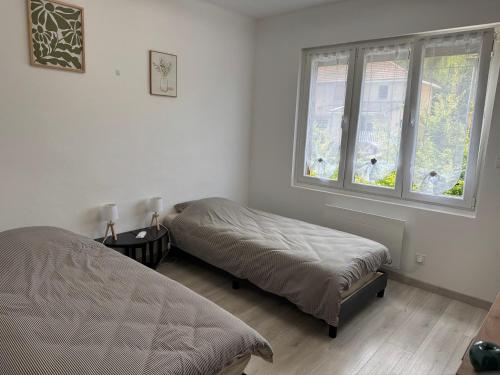 une chambre avec deux lits et une fenêtre dans l'établissement Gîte des Prés, à Revin