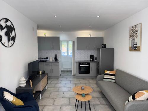 un salon avec un canapé et une cuisine dans l'établissement Gîte des Prés, à Revin