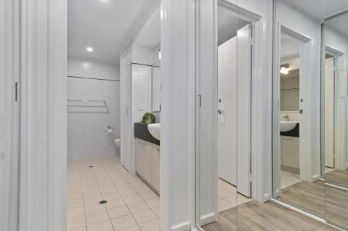 een badkamer met twee wastafels en een spiegel bij Cityscape on Mounts Bay in Perth