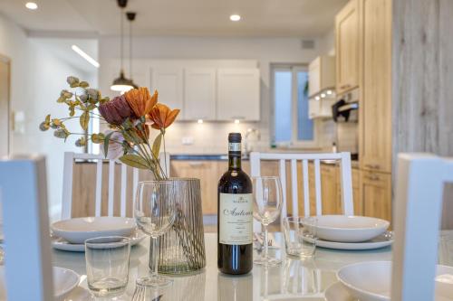 a bottle of wine sitting on a table with glasses at Gharghur Apartment - Baby Gear, Office & Parking in Għargħur