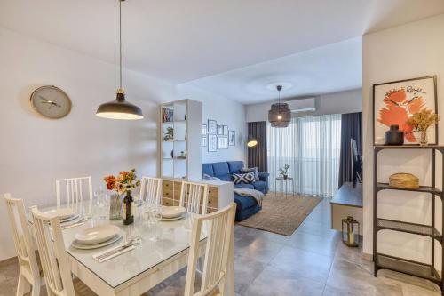 a dining room and living room with a table and chairs at Gharghur Apartment - Baby Gear, Office & Parking in Għargħur