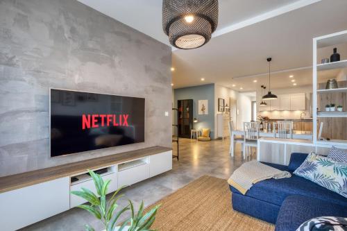 a living room with a blue couch and a tv at Gharghur Apartment - Baby Gear, Office & Parking in Għargħur