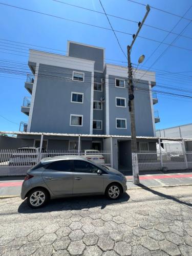 チジュカスにあるAurora Borealの建物の前に駐車された小型車