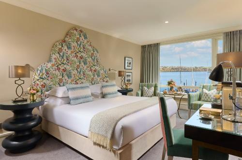 a bedroom with a large bed with a large window at Trident Hotel Kinsale in Kinsale