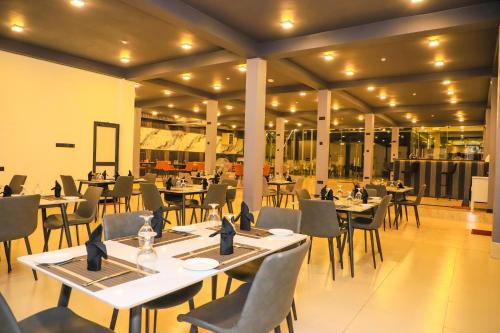 ネゴンボにあるThe Galaxy Airport Hotelの建物の中にテーブルと椅子があるレストラン