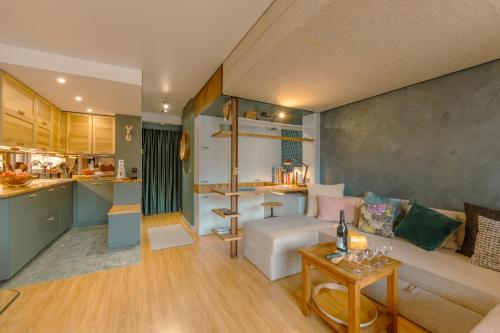 Una sala de estar con un sofá y una cocina. en Le Balcon du Brévent - Happy Rentals, en Chamonix-Mont-Blanc