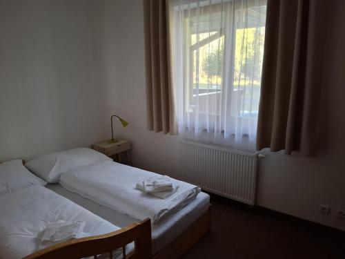 a bedroom with two beds and a window at Lomnica Orange Apart in Tatranská Lomnica