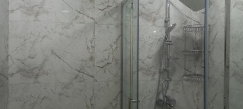 a shower in a bathroom with a glass door at Gusar Apartment in Qusar
