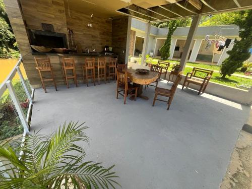eine Terrasse mit einem Tisch und Stühlen sowie einer Bar in der Unterkunft Refúgio dos Pássaros in Campo Largo