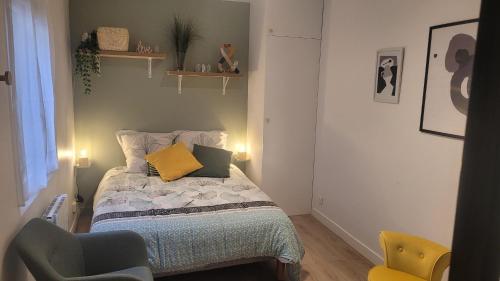 a small bedroom with a bed and a chair at Maisonnette avec jardin proche Paris in Saint-Mandé