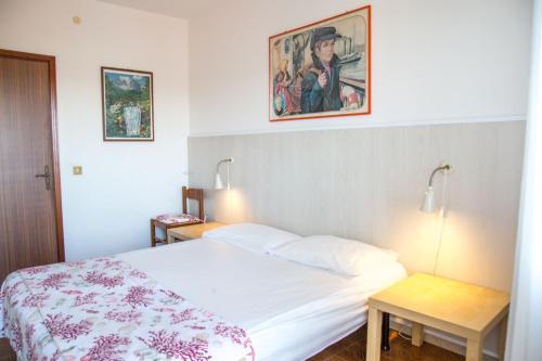 Un dormitorio con una cama y un cuadro en la pared. en Downtown apartment by the beach, en Eraclea Mare