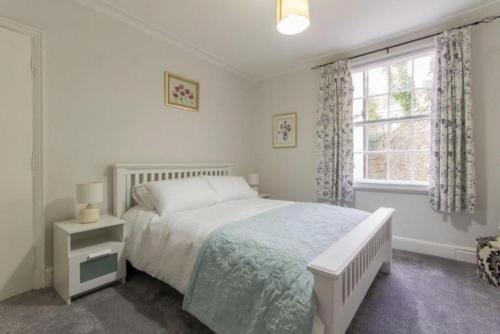 een witte slaapkamer met een bed en een raam bij 7 Bed in Matlock Bath oc-n34368 in Cromford