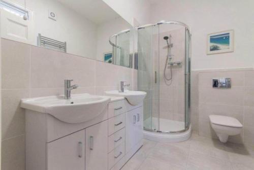 een badkamer met 2 wastafels, een douche en een toilet bij 7 Bed in Matlock Bath oc-n34368 in Cromford