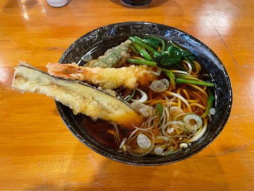 eine Schüssel Essen mit Nudeln und ein Stück Brot in der Unterkunft Le Cave Troll ル カーブ トロル in Mitaka