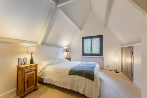 une chambre avec un grand lit et une fenêtre dans l'établissement Le Bois Fleuri - 7500 m² de jardin, à La Couture-Boussey