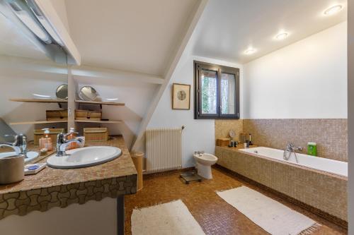 une salle de bains avec lavabo, baignoire et toilettes dans l'établissement Le Bois Fleuri - 7500 m² de jardin, à La Couture-Boussey