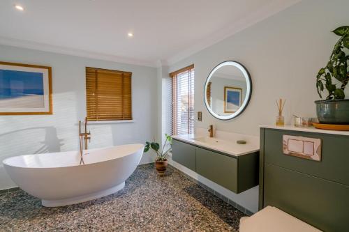 een badkamer met een bad, een wastafel en een spiegel bij 5 Bed in Spean Bridge oc-t34246 in Spean Bridge