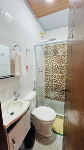 a bathroom with a toilet and a sink and a shower at Pousada Zen in Angra dos Reis