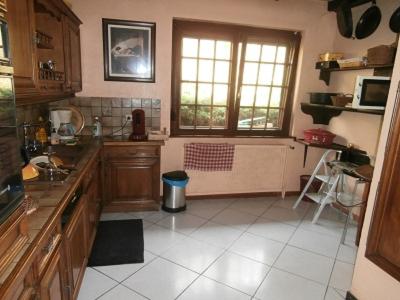 a kitchen with wooden cabinets and a tile floor at B&B Ma Maison Hautes Vosges in Ranspach