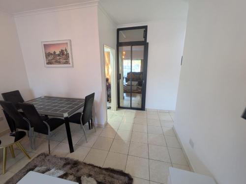 Manna guest house في هراري: غرفة طعام وغرفة معيشة مع طاولة وكراسي