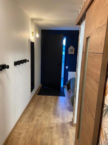 a hallway with a black door and a wooden floor at Appartement 203 in Saint-Lary-Soulan