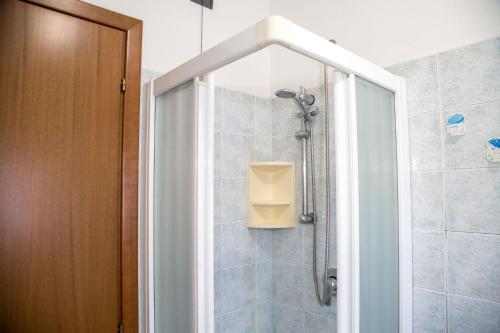 um banheiro com chuveiro com porta de vidro em Ground-floor haven just 350mt from the beach em Eraclea Mare