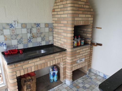 La cuisine est équipée d'un four en briques et d'un évier. dans l'établissement Sitio Recanto dos Passáros, à Caçapava