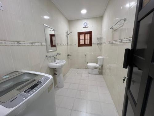 ein weißes Badezimmer mit Waschbecken und Toilette in der Unterkunft Your Cozy Stay in Bahrain in Jurdāb