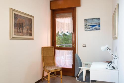 Camera con sedia, scrivania e finestra. di Terrazza Alpina in centro Barzio a Barzio