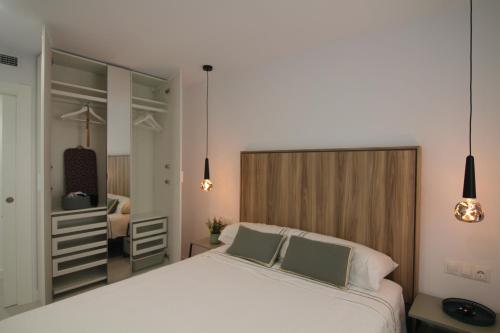 Un dormitorio con una gran cama blanca y un espejo. en Alameda 16 Apartment Beach Old Town, en Benidorm