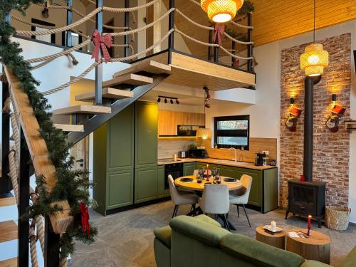 a kitchen and living room with a spiral staircase at Kolibe Doftana in Trăisteni
