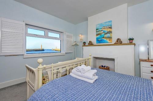 ein Schlafzimmer mit einem blauen Bett mit Handtüchern darauf in der Unterkunft Finest Retreats - No 3 Sandside in Whitby