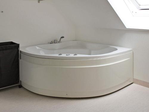 a white bath tub in a room with a window at Panoramic Golf View Retreat - By Traum Ferienwohnungen in Sønderby