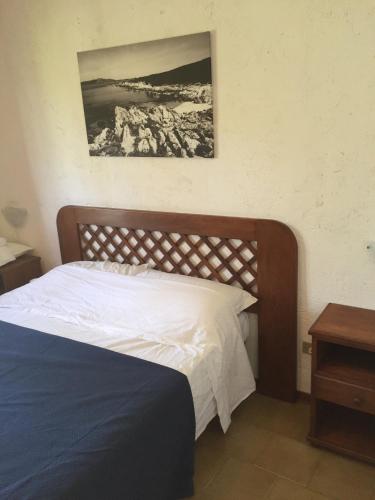 a bedroom with a bed with a wooden headboard at Appartamenti Baia Smeralda in Santa Marinella