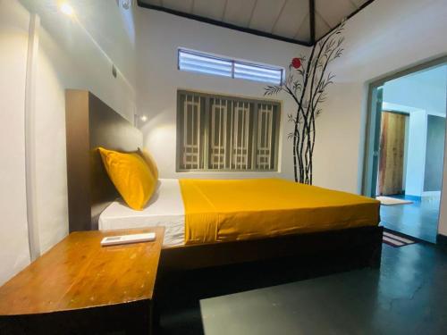 Un pat sau paturi într-o cameră la Mango House Hiriketiya