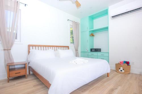 um quarto com uma grande cama branca e uma janela em West Ends Best Kept Secret The Comfy Sloth em West End