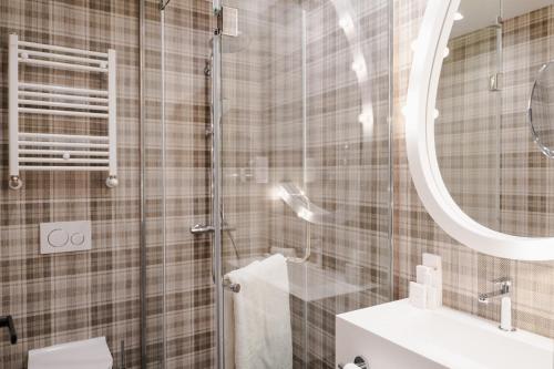 a bathroom with a shower and a toilet and a sink at Mamaison Vibe Hotel Downtown Budapest in Budapest