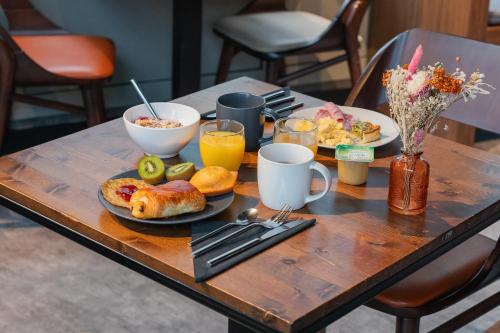 - une table en bois avec des assiettes de nourriture et de boissons dans l'établissement Appart'City Collection Paris Gare de Lyon, à Paris