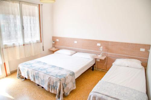 um quarto de hospital com duas camas e uma janela em Two bedroom flat close to the beach in Eraclea em Eraclea Mare