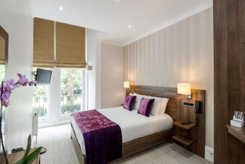 una camera d'albergo con letto e finestra di London House Hotel a Londra