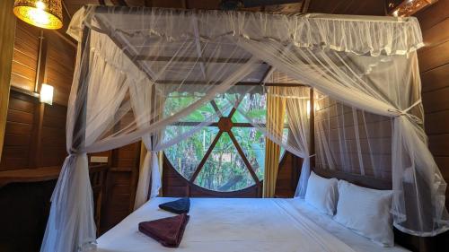 um quarto com uma cama de dossel e uma janela em Abraham Beach House em Tangalle