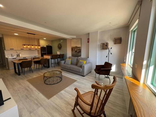 ein Wohnzimmer und eine Küche mit einem Sofa und Stühlen in der Unterkunft Apartamento los Remos VUT-3207AS in Llanes