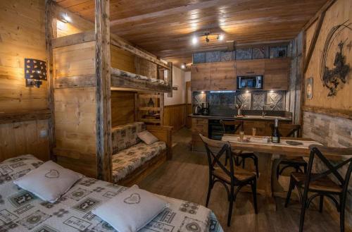 een kamer met 2 bedden en een tafel met stoelen bij Les Champis in La Bresse