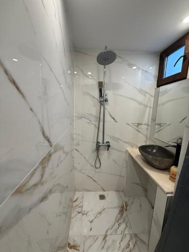 a white bathroom with a shower with a sink at Guest House MARAVILA in Belogradchik
