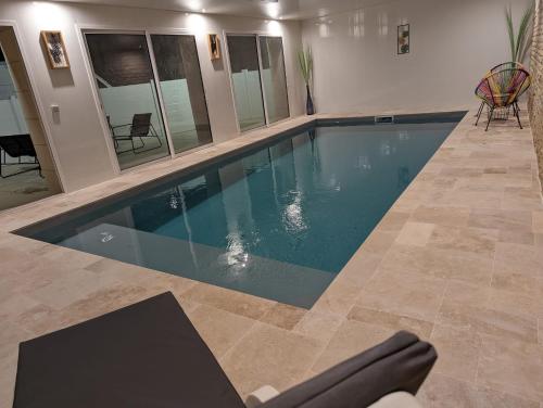 ein Pool mit blauem Wasser in einem Haus in der Unterkunft Gîte proche du Futuroscope in Jaunay-Clan