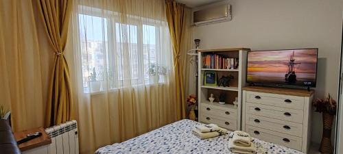 Un dormitorio con una cama y una cómoda con televisión. en Abel Luxury Home, en Constanţa