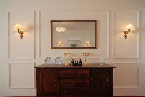 uma casa de banho com um espelho e uma cómoda em madeira em The Hundred House by Kisah Stays - Wayanad Colonial Estate Bungalow em Ambalavayal