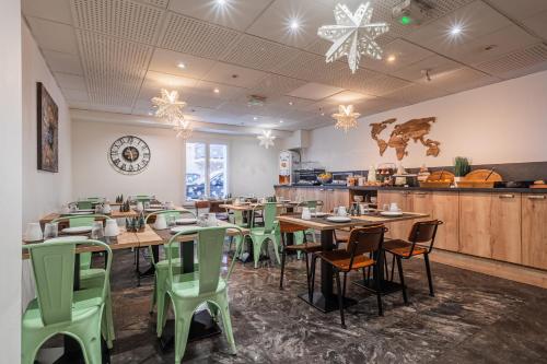 um restaurante com mesas de madeira e cadeiras verdes em Residhotel Mulhouse Centre em Mulhouse